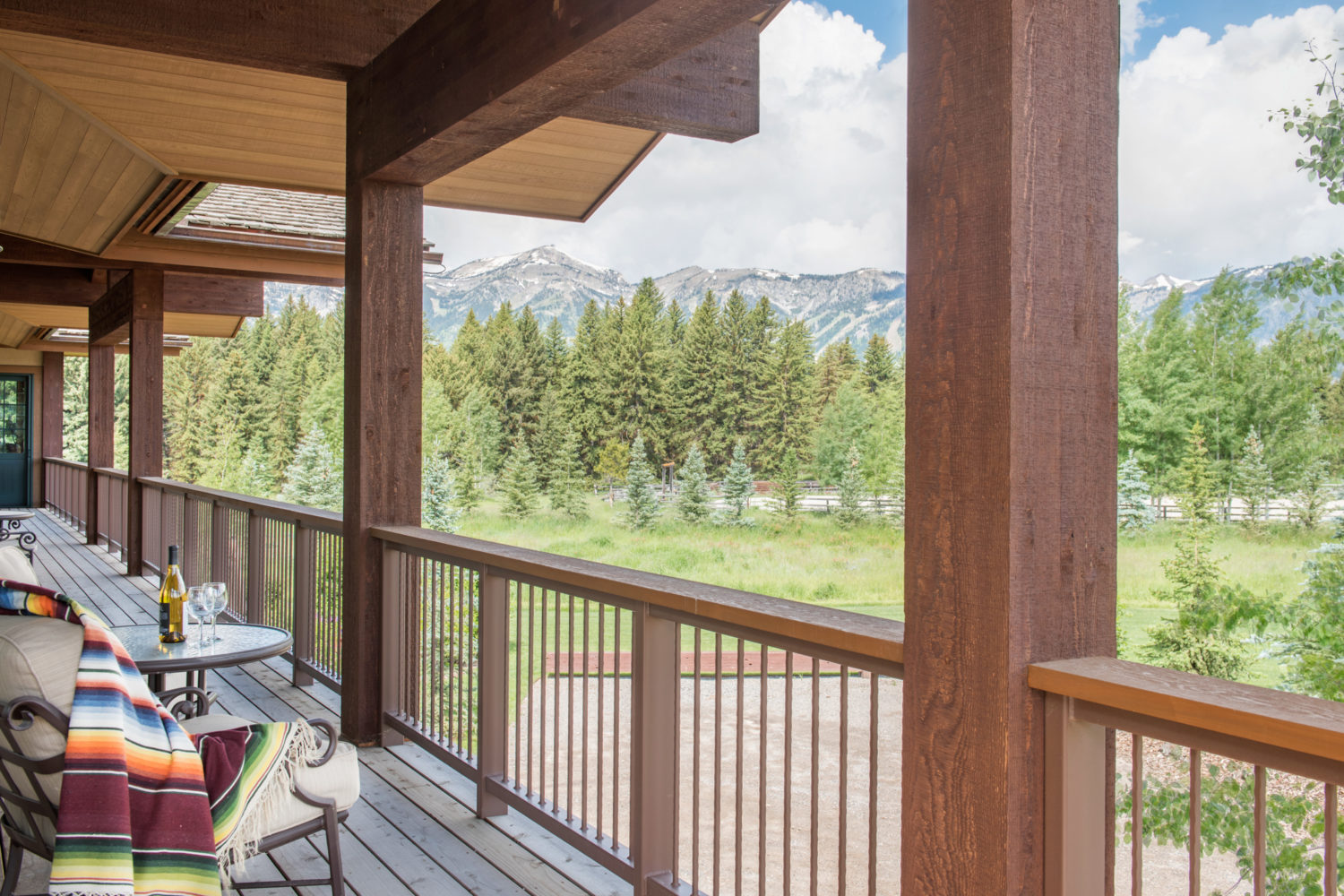 A balcony with furniture and views of trees and mountains