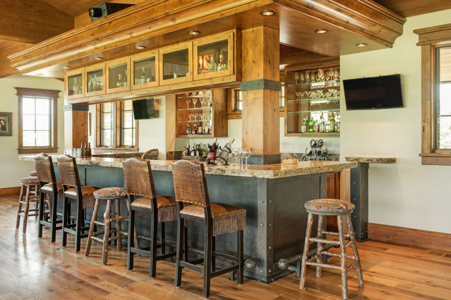 A large bar with glasses and barstools