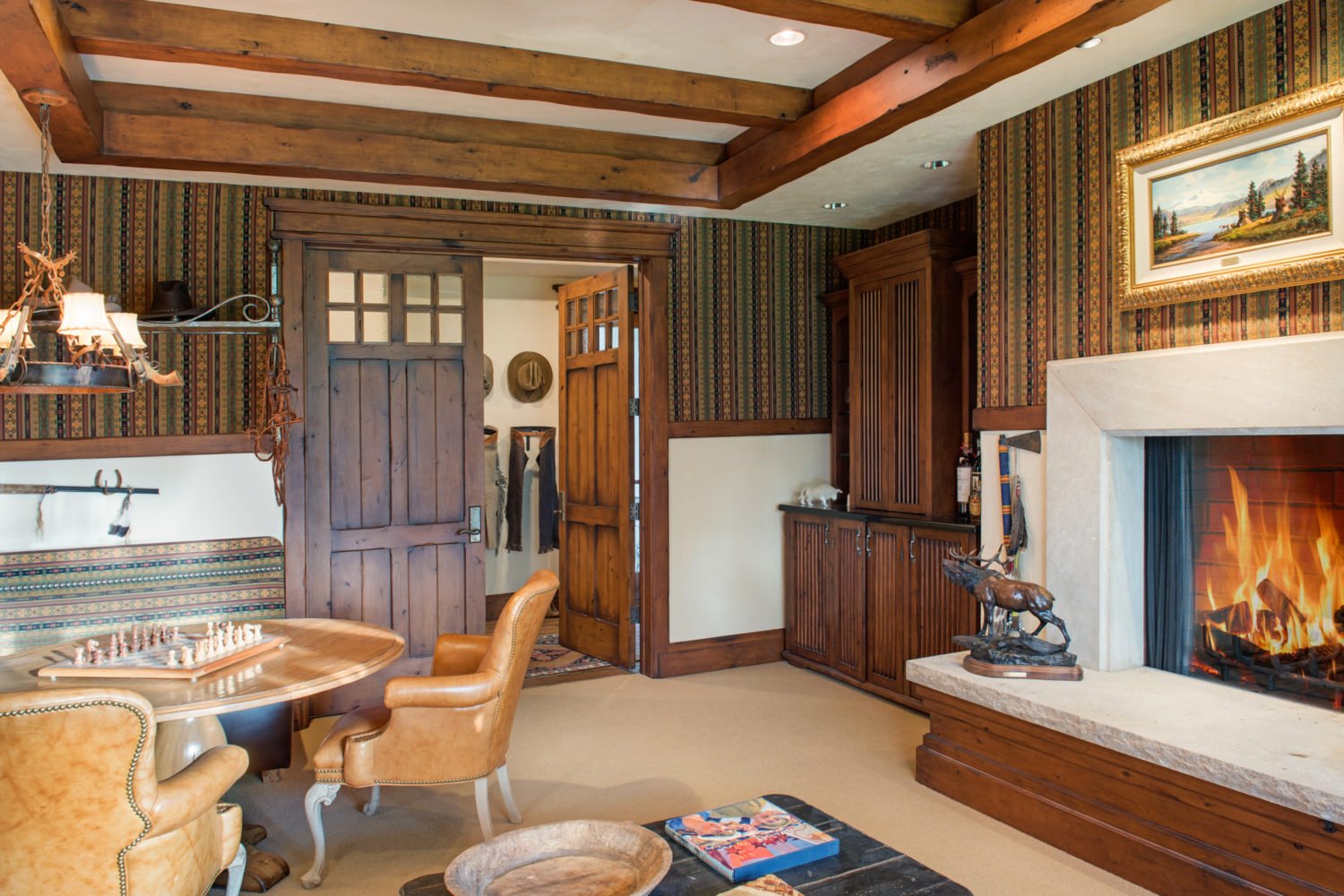 A wood-paneled room with a chess table and fireplace