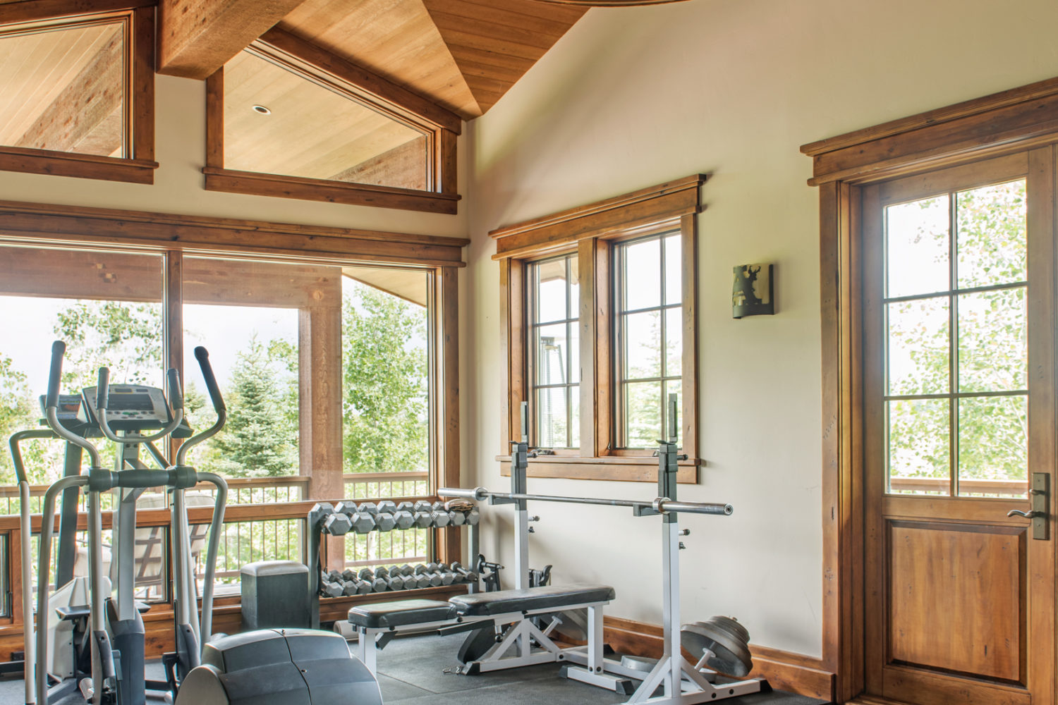 A large room with exercise equipment and windows viewing the outside