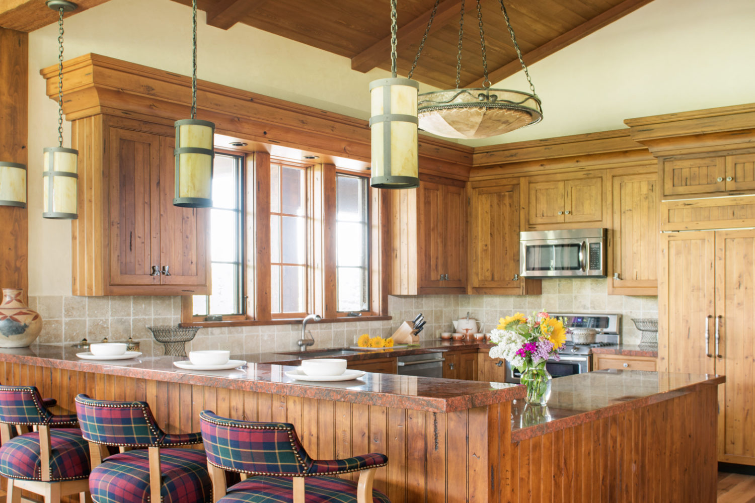 A spacious kitchen with a wraparound counter and barstools