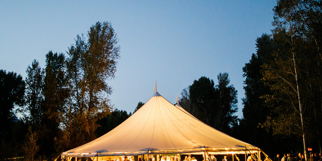 A large tent with guests enjoying a reception at night